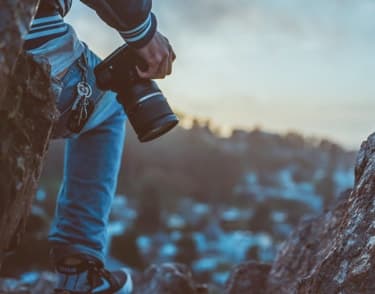 Close-up of a person holding a camera outdoors