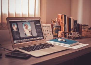 Laptop on a desk with printed photos