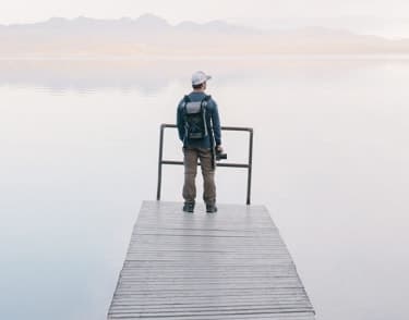 Person standing on a dock at sunset