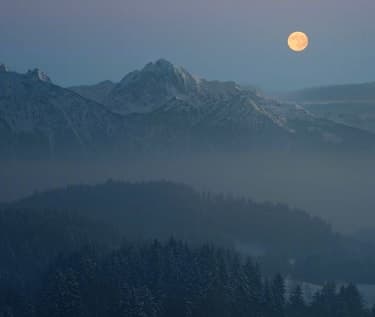 Moon over a mountain landscape at dusk